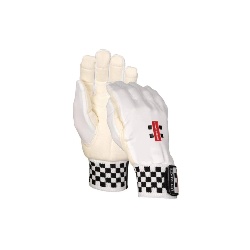 A pair of Gray Nicolls wicket keeping gloves with chamois padded inners, featuring a white and black color scheme with a checkered pattern on the wrist strap.